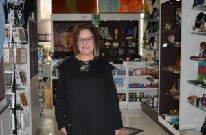 Image of Carolyn Osborn, Creative Forces Owner, in front of her shop at the Hotel Murano
