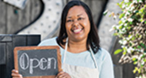 Person holding small business open sign